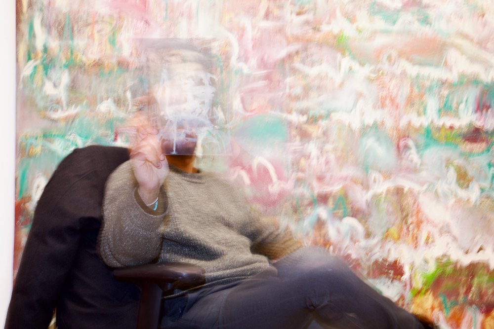 The artist seated before a painting, his face hidden behind a small painted work